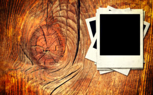 Old and dark wooden wall with blank photo frame